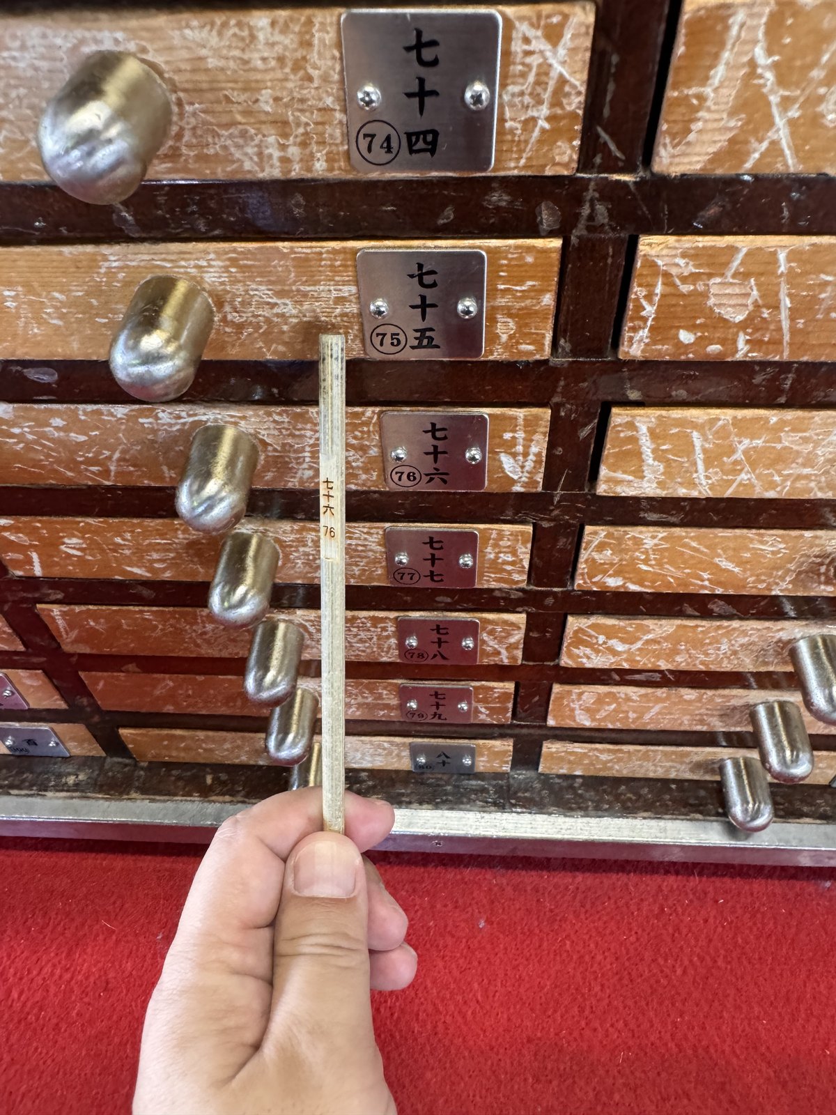 Drawing an omikuji fortune stick from the numbered drawers at Senso-ji