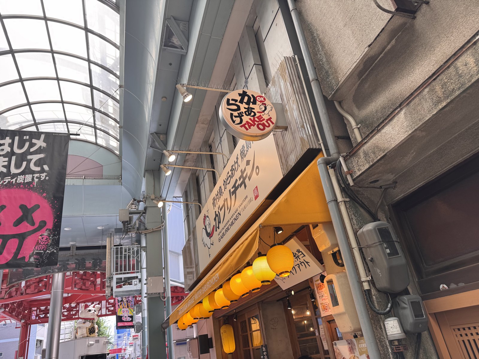 The same Gaburi Chicken shopfront at 12:50, open with lanterns lit and a takeaway sign out