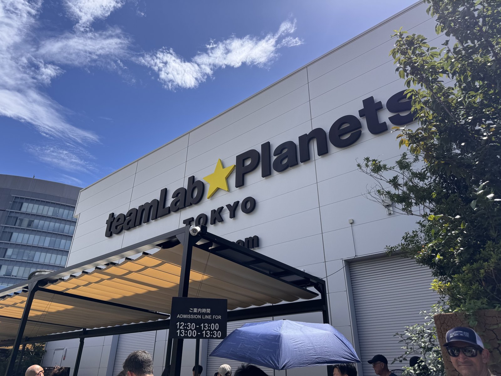 The exterior sign of teamLab Planets TOKYO in Toyosu against a blue sky