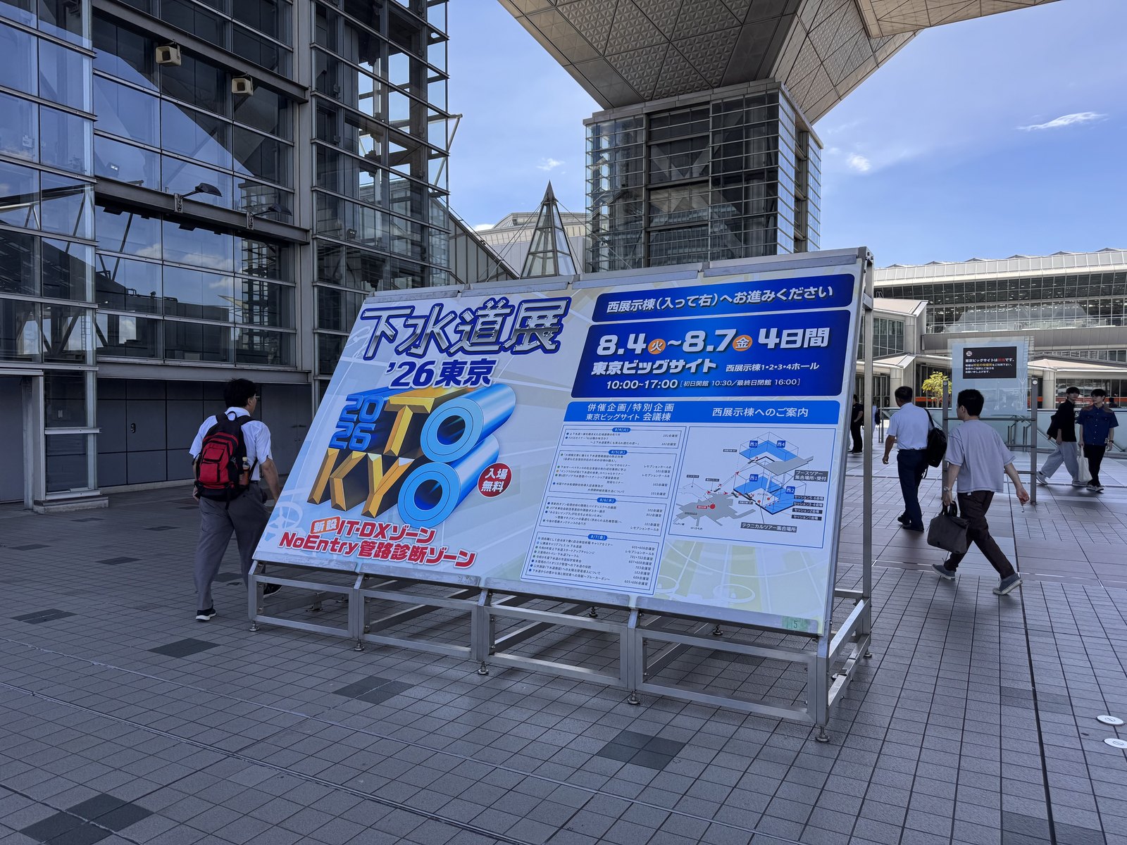A signboard outside Tokyo Big Sight showing the dates and hall map for a trade exhibition