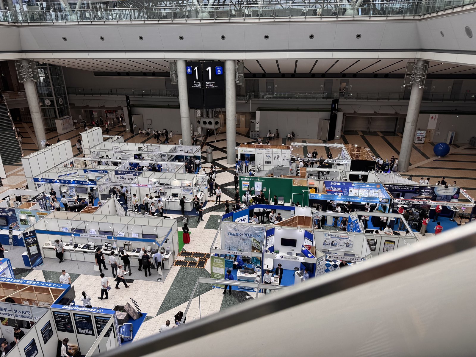 Rows of exhibition booths filling a hall at Tokyo Big Sight, seen from above