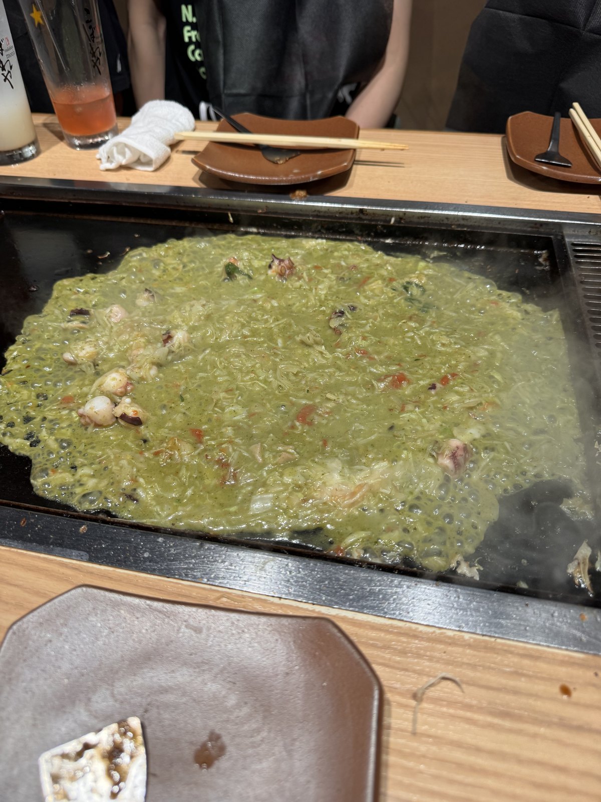 A green monjayaki made with octopus and house-made pesto on the griddle