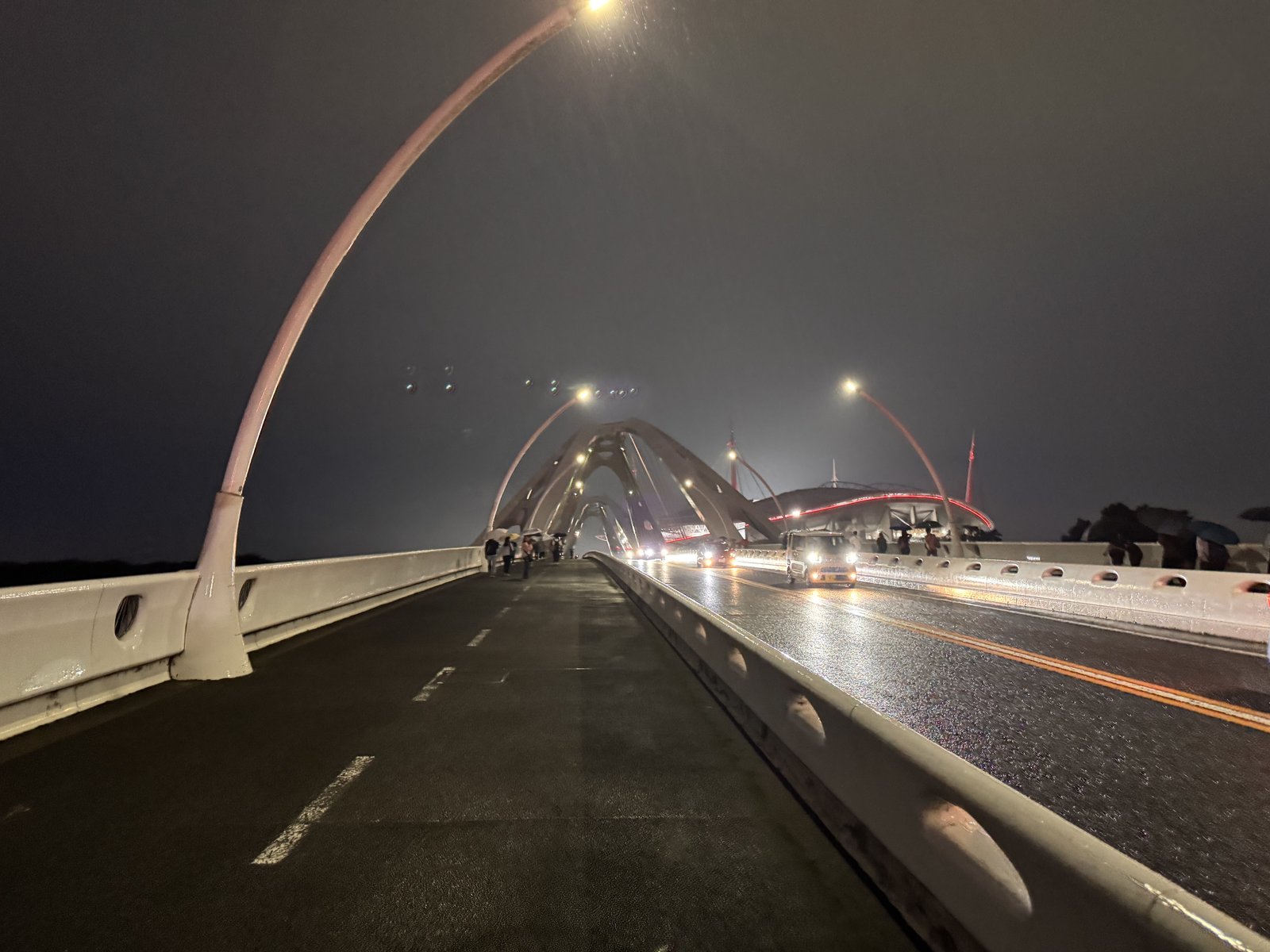 雨の夜、豊田スタジアムへ向かう橋の歩道