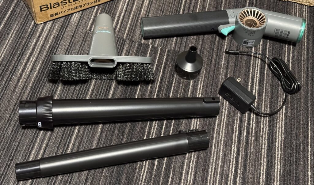 Shark BlastBossの本体と付属品。組み立て前の延長パイプ2本、床用ブラシ、ノズル、充電器